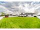 Expansive backyard showcasing a pristine lawn, privacy fence, mature trees and patio area at 838 Deerfield Rd, Anderson, IN 46012