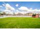 Spacious backyard with a lush green lawn, privacy fence, and a storage shed at 838 Deerfield Rd, Anderson, IN 46012