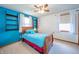 Stylish bedroom with bright blue accent wall, shelving, and window, creating a vibrant space at 838 Deerfield Rd, Anderson, IN 46012