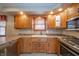 Well-lit kitchen features wooden cabinets, stainless steel appliances, and a double sink at 838 Deerfield Rd, Anderson, IN 46012