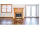 Cozy living room featuring a fireplace, hardwood floors, and a bright window at 838 Deerfield Rd, Anderson, IN 46012