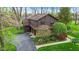 Aerial view of a home with stone and wood accents, well-maintained landscaping, and a paved driveway at 889 Cedar Wood Pl, Carmel, IN 46032