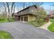 Home with stone accents, a three car garage and a paved driveway with mature landscaping at 889 Cedar Wood Pl, Carmel, IN 46032