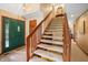 Foyer staircase with wood railing and carpeted steps leading to the upper level at 889 Cedar Wood Pl, Carmel, IN 46032