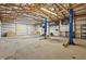 Fully-equipped garage interior with ramp, lift, shelving, and ample space for your projects at 911 W Washington Ave, Shelbyville, IN 46176