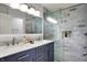 Bathroom featuring a dual sink vanity, a glass enclosed shower, and modern fixtures at 9309 Golden Woods Dr, Indianapolis, IN 46268