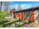 Exterior view of a brick home with well-maintained lawn, mature trees, and an air conditioning unit, inviting and comfortable at 9309 Golden Woods Dr, Indianapolis, IN 46268