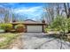 Charming single-story home with attached garage, brick facade, and mature trees, perfect for suburban living at 9309 Golden Woods Dr, Indianapolis, IN 46268