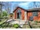 Red brick home featuring a sliding glass door, concrete patio, and well-maintained landscaping, ideal for outdoor living at 9309 Golden Woods Dr, Indianapolis, IN 46268