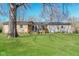 A spacious backyard with a well-maintained lawn and a small wooden deck accessible through sliding glass doors at 9535 E Michigan St, Indianapolis, IN 46229
