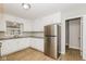 Functional kitchen featuring white cabinets, granite countertops, a stainless steel refrigerator and laminate floors at 9535 E Michigan St, Indianapolis, IN 46229