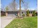 Charming single-story brick home with a well-maintained lawn, mature trees, and an attached two-car garage at 9814 E 17Th St, Indianapolis, IN 46229