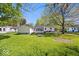 Lush backyard featuring mature trees and an enclosed back porch at 102 Florence Dr, Greenwood, IN 46143