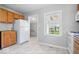 Spacious kitchen boasts bright white appliances, wood cabinets, and luxury vinyl tile flooring at 102 Florence Dr, Greenwood, IN 46143