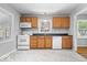 Well-lit kitchen featuring white appliances, wood cabinets, and new modern flooring at 102 Florence Dr, Greenwood, IN 46143