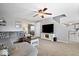 Spacious living room features a ceiling fan, large television, and an open staircase at 10883 Balfour Dr, Noblesville, IN 46060