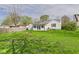 White house from the backyard with a fence and green grass, showcasing the outdoor space at 1327 Lindberg Rd, Anderson, IN 46012