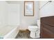 Bathroom with white tile walls, dark stone-look flooring, and a single window at 1327 Lindberg Rd, Anderson, IN 46012