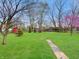 Expansive backyard with lush green grass, blooming trees, and a charming red shed at 1331 Dunlap Ave, Indianapolis, IN 46241