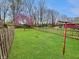 Lush backyard with manicured lawn, blooming spring trees, and a classic clothesline at 1331 Dunlap Ave, Indianapolis, IN 46241