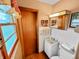 Bright bathroom with white tiled walls, wooden accents, and a window providing natural light at 1331 Dunlap Ave, Indianapolis, IN 46241