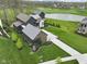 Aerial view of a home with a metal roof, a long driveway, a well-kept lawn, and a lush golf course at 1333 Chatham Rdg Ct, Westfield, IN 46074