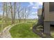 Backyard with a staircase, manicured lawn, rock border, mature trees, and views of the lake and golf course at 1333 Chatham Rdg Ct, Westfield, IN 46074