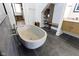 Modern bathroom featuring a unique stone bathtub, dark tile floors and custom shelving at 1333 Chatham Rdg Ct, Westfield, IN 46074