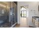 Sleek bathroom showcasing glass shower with dark tile, spacious walk-through design, and modern vanity with round mirror at 1333 Chatham Rdg Ct, Westfield, IN 46074