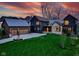 Stunning exterior elevation of this modern home with well manicured yard and three-car garage at dusk at 1333 Chatham Rdg Ct, Westfield, IN 46074