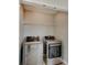 Laundry closet with a shelf above a modern washer and dryer set at 13392 Dorster St, Fishers, IN 46037