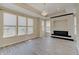 Open living room area with modern fireplace, large windows, and elegant light fixture at 13392 Dorster St, Fishers, IN 46037