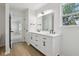 Bathroom featuring a double vanity with black fixtures and a large mirror at 13562 Silver Spur, Carmel, IN 46032