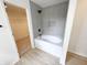 Bathroom features a tub with tiled walls and a tiled storage alcove at 13562 Silver Spur, Carmel, IN 46032