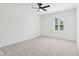Bright bedroom featuring neutral carpeting, ceiling fan, and well-lit window at 13562 Silver Spur, Carmel, IN 46032