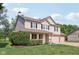 Two-story home with covered front porch, brick accents, and a large garage surrounded by a lush green lawn at 13562 Silver Spur, Carmel, IN 46032