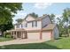 Charming two-story home with a covered front porch, brick accents, a large garage and mature trees on a large lot at 13562 Silver Spur, Carmel, IN 46032