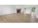 Open-concept living area featuring a brick fireplace, light wood-look flooring, and views of the backyard at 13562 Silver Spur, Carmel, IN 46032