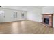 Inviting living room features a charming brick fireplace, neutral walls, and wood-look flooring for a clean aesthetic at 13562 Silver Spur, Carmel, IN 46032