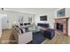 Bright, staged living room with a cozy brick fireplace, plush sofas, and large windows with natural light at 13562 Silver Spur, Carmel, IN 46032