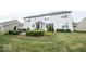 Backyard view of a two-story home with a patio, garden beds, and a well-maintained lawn surrounded by mature trees at 13717 Van Buren Pl, Fishers, IN 46038