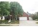 Elegant two-story brick home with a three-car garage and a spacious driveway surrounded by mature trees and landscaping at 13717 Van Buren Pl, Fishers, IN 46038