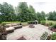 Outdoor patio featuring a comfortable seating area, fire pit, and grill, perfect for entertaining guests in a serene backyard setting at 13717 Van Buren Pl, Fishers, IN 46038