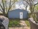 Backyard with detached garage features a partial view of a deck with grill and chair and a partially fenced yard at 1429 Fletcher Ave, Indianapolis, IN 46203
