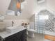 Bright bathroom features tiled floors, tiled shower and unique mirror over vanity with modern basin sink at 1429 Fletcher Ave, Indianapolis, IN 46203