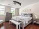 Cozy bedroom features a ceiling fan, hardwood floors, and natural light from the large window at 1429 Fletcher Ave, Indianapolis, IN 46203