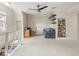 Bright bonus room features neutral walls, ceiling fan, carpeted floors and built in shelving with a gray sofa at 1429 Fletcher Ave, Indianapolis, IN 46203