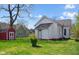 Backyard view shows a white house, green lawn, and a small red shed with white trim at 1509 Sycamore St, Columbus, IN 47201