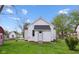 Well-maintained backyard featuring a white house with green grass and a shed in the distance at 1509 Sycamore St, Columbus, IN 47201