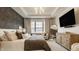 Bedroom showcasing a tray ceiling, accent wall, and a comfortable sitting area complemented by a large mirror at 15655 Woodford Dr, Westfield, IN 46074